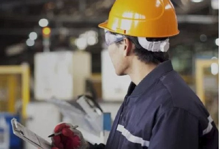 trabalhador de capacete laranja e macacão azul marinho