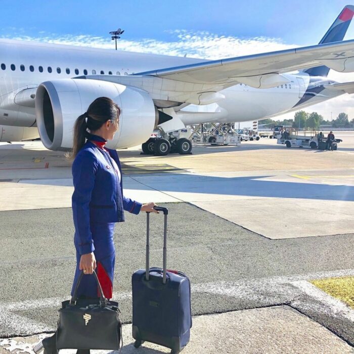 LATAM flight attendant holding a suitcase. Photo: Latam
