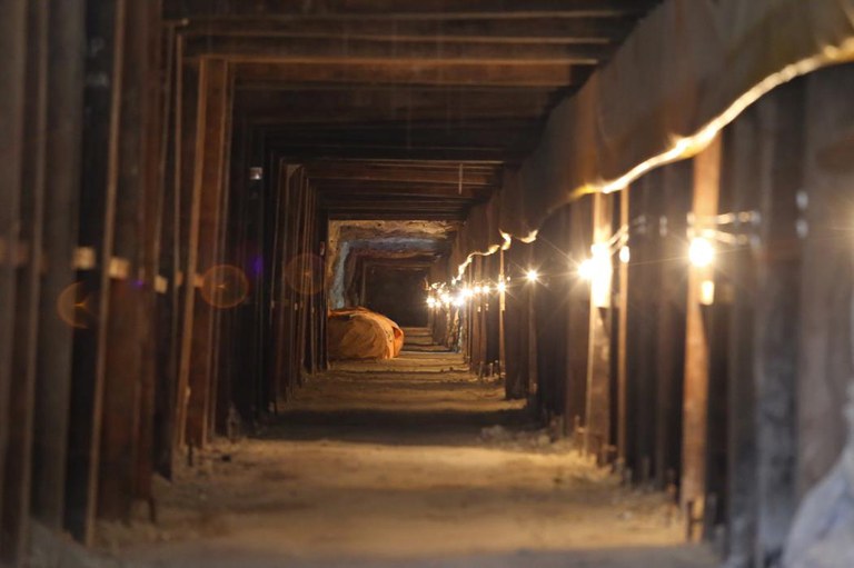Interior de uma mina de urânio com iluminação artificial, estrutura reforçada e sinais de atividade subterrânea no Projeto Santa Quitéria, Ceará.