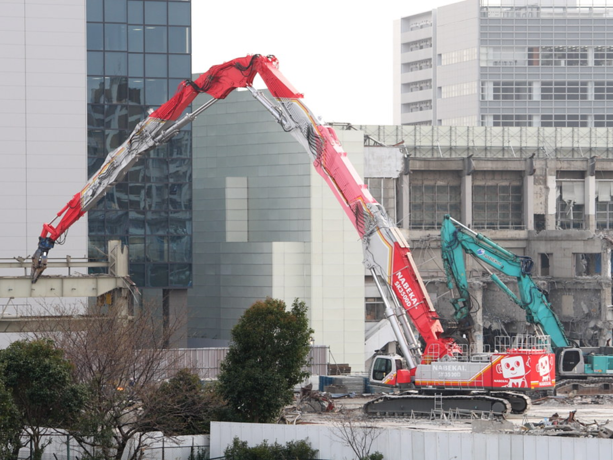 Conheça a Kobelco SK3500D, a escavadeira para demolição de 328t que, com 65m de alcance, demole prédios de 21 andares do solo.