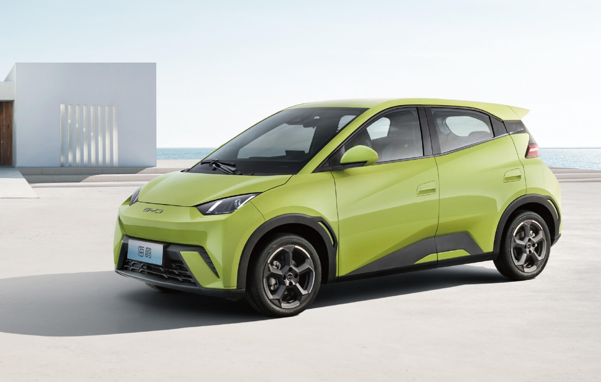 Carro elétrico BYD Seagull verde-limão estacionado próximo ao mar em ambiente moderno