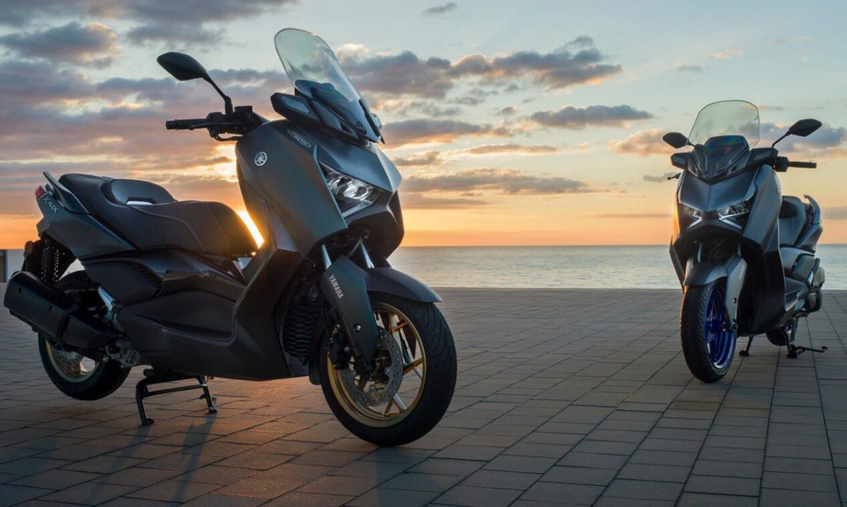 Scooters Yamaha XMAX 300 estacionadas com vista para o mar ao pôr do sol