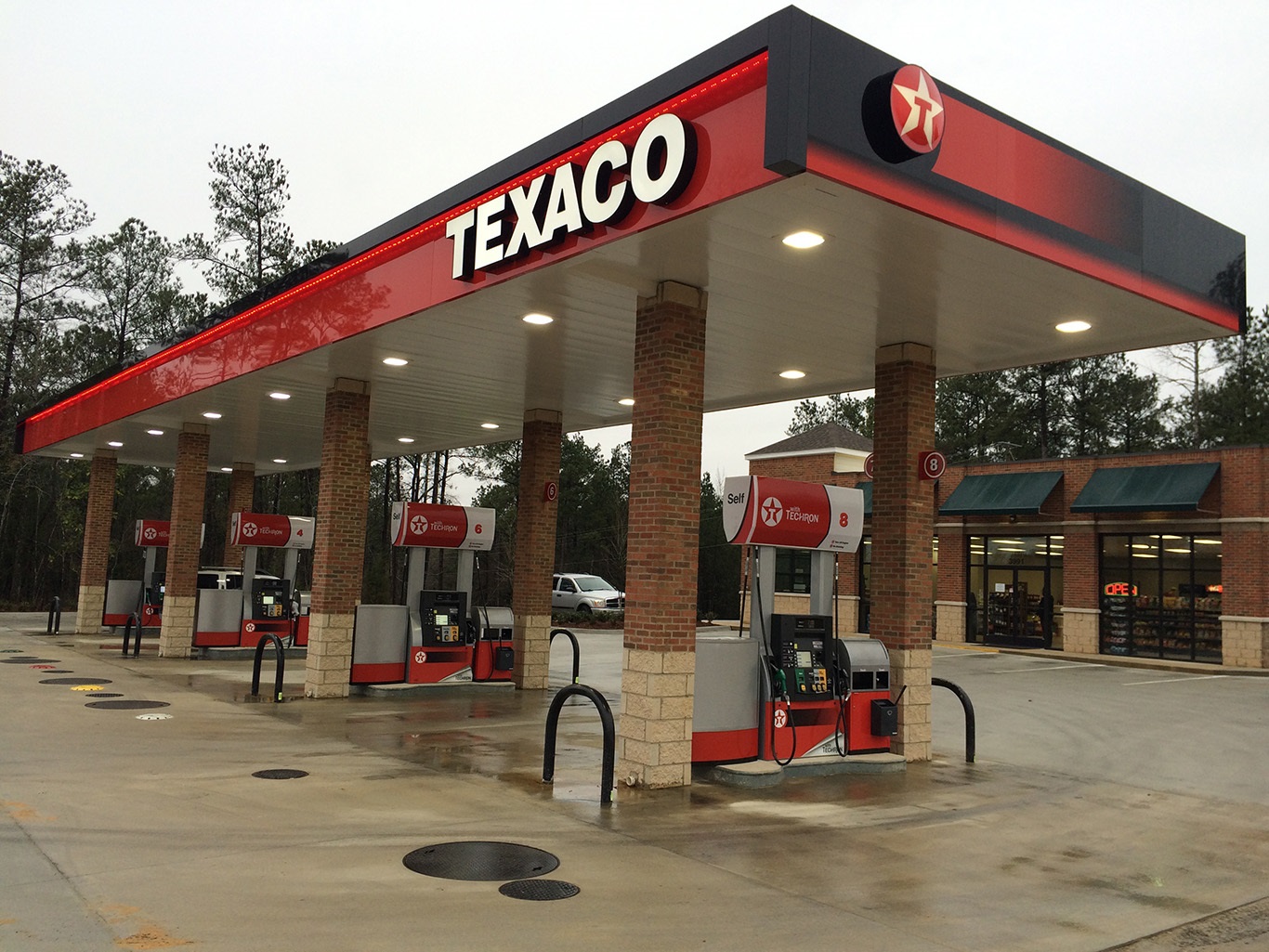 Posto de combustíveis Texaco com bombas de abastecimento e loja de conveniência ao fundo