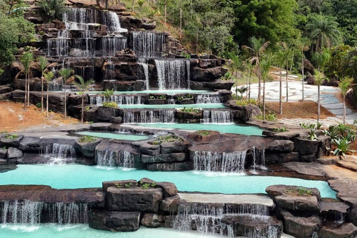 Cachoeira artificial em degraus com piscinas naturais em parque tropical