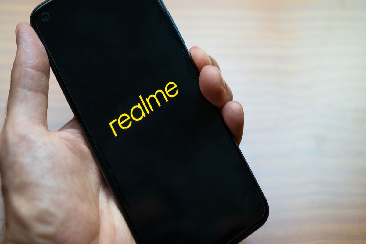 Pessoa segurando smartphone com logotipo da Realme na tela