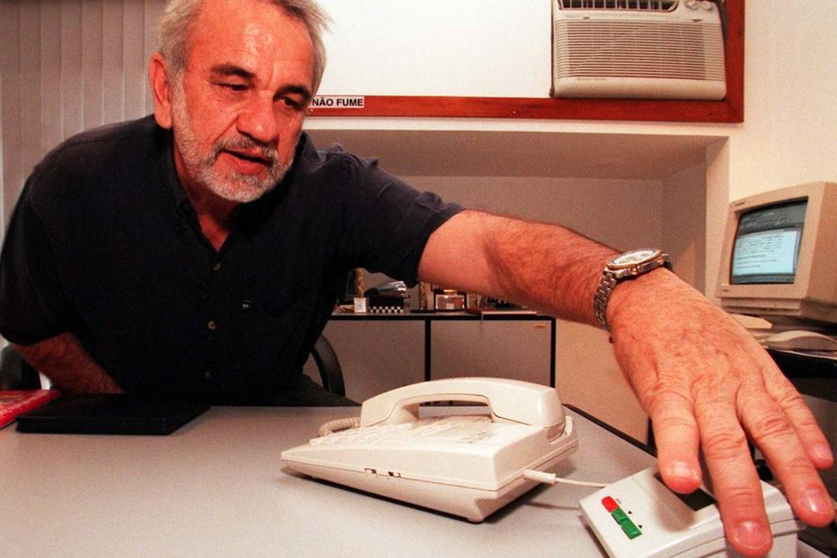 Foto de um aparelho de Bina, o identificador de chamadas, ao lado de um telefone antigo, ilustrando a história da invenção brasileira.