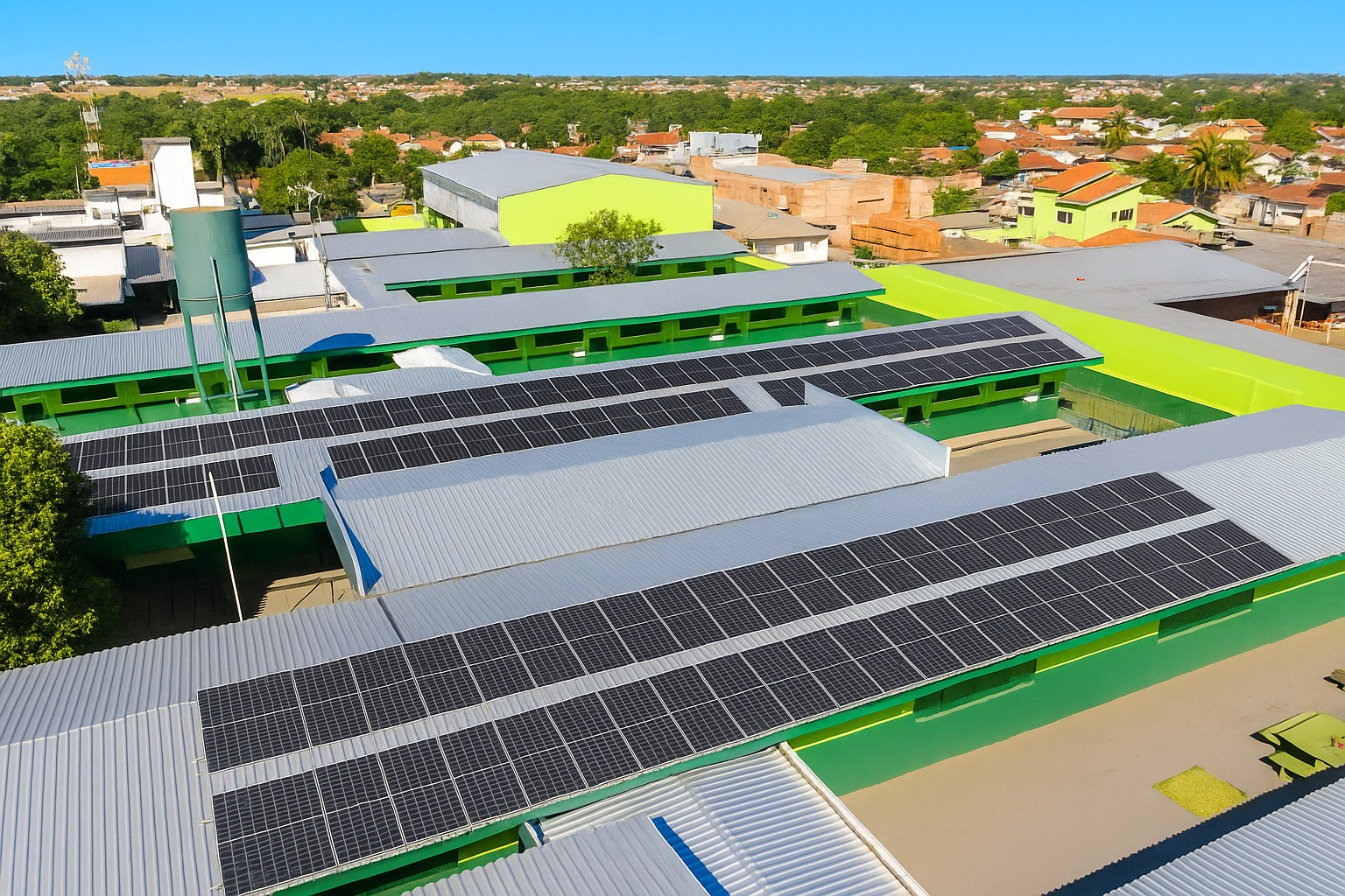 Vista aérea de painéis solares instalados em telhados sob luz solar intensa ao meio-dia