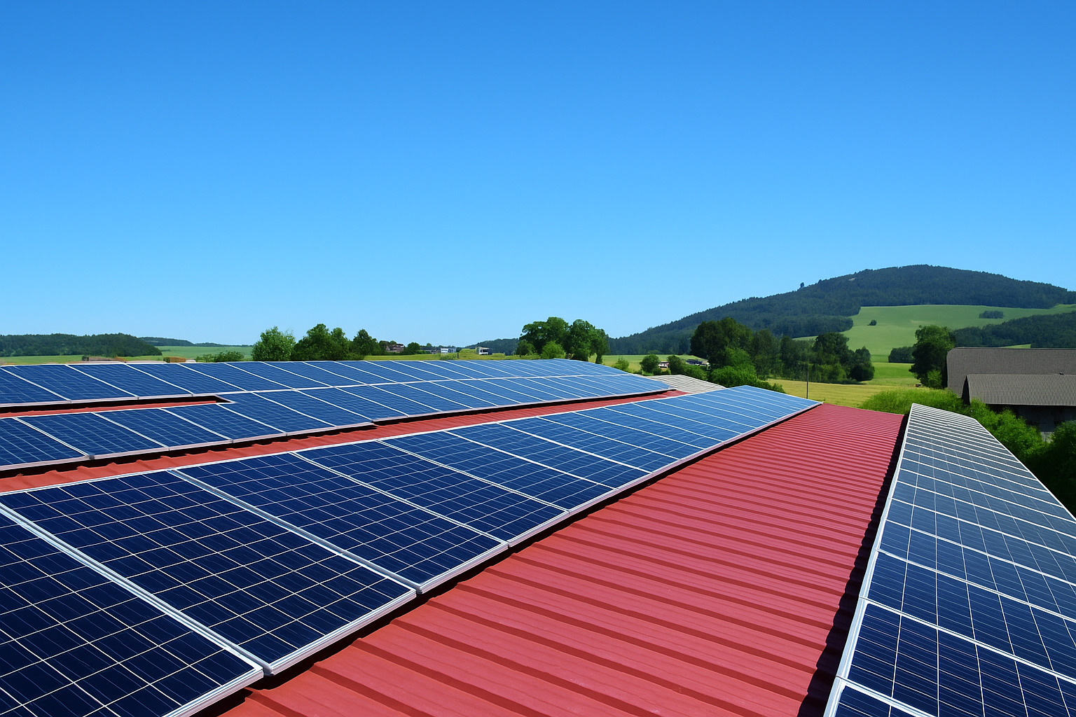 Painéis solares instalados em telhado vermelho com uma fileira removida e céu limpo ao fundo