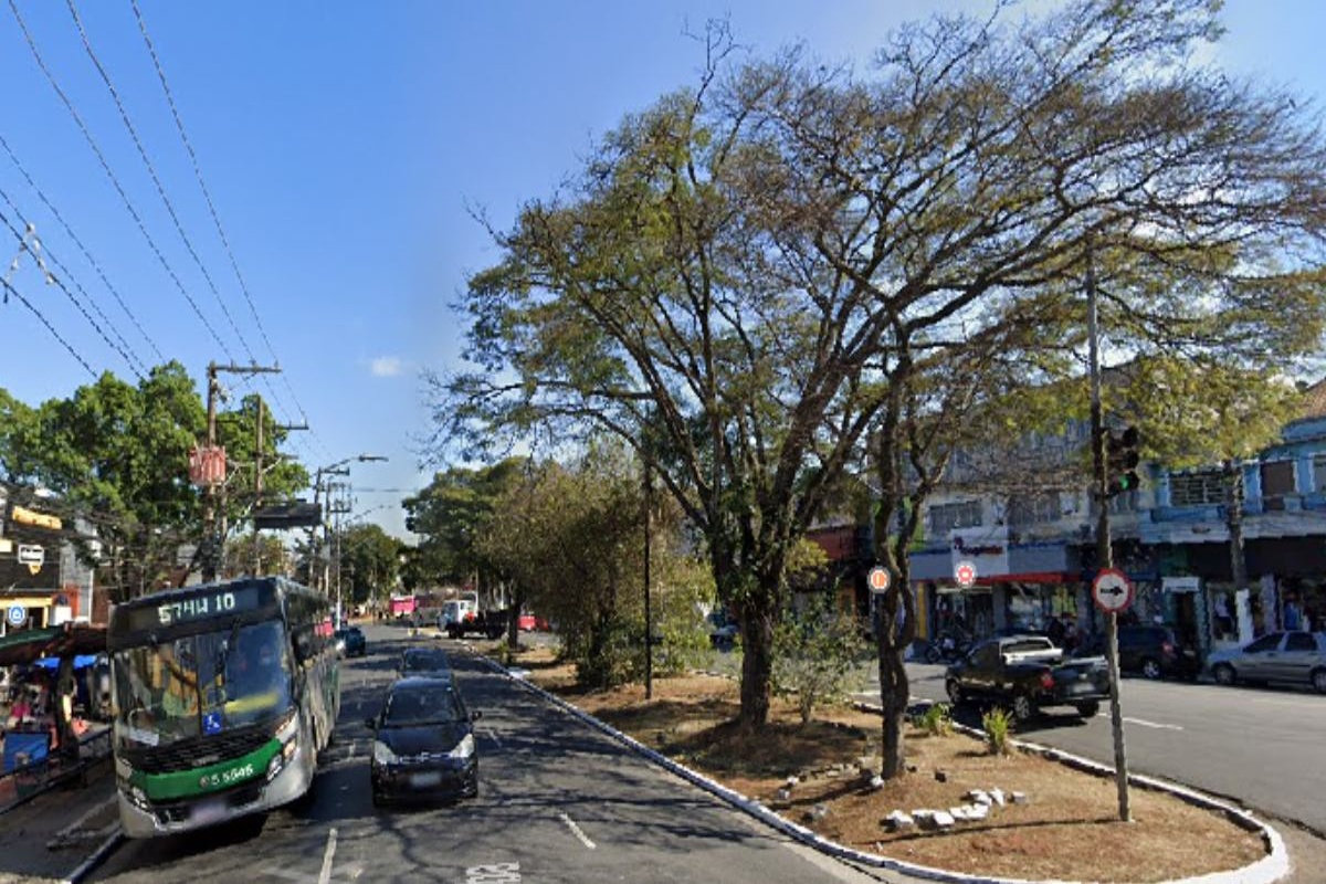 Avenida Sapopemba com ônibus, carros e árvores em dia ensolarado