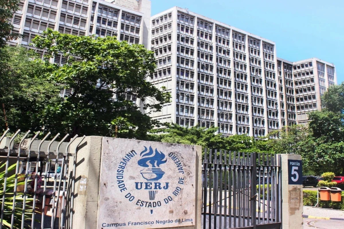 Fachada principal da UERJ com portão de entrada e prédio ao fundo