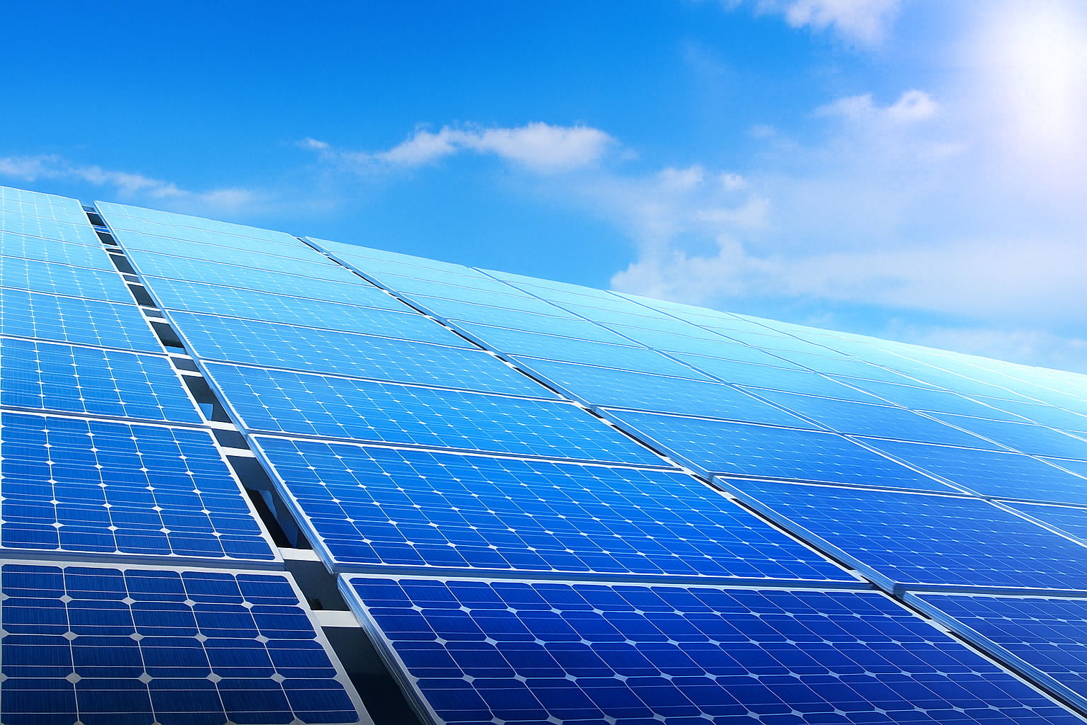 Painéis solares sob céu azul limpo em dia ensolarado.