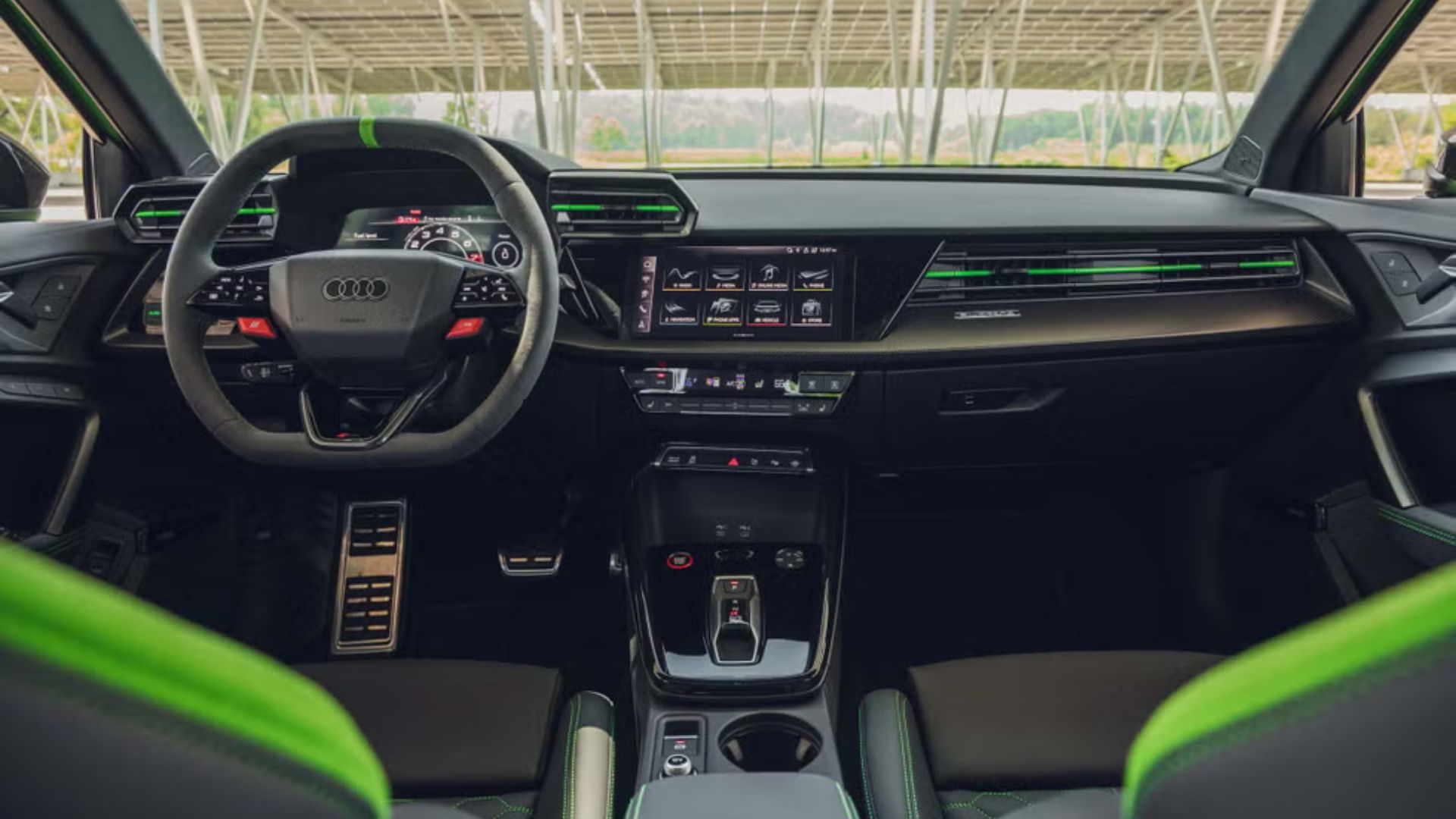 Audi RS3 2025 fazendo curva em pista de corrida com fundo montanhoso e difusor traseiro em destaque.