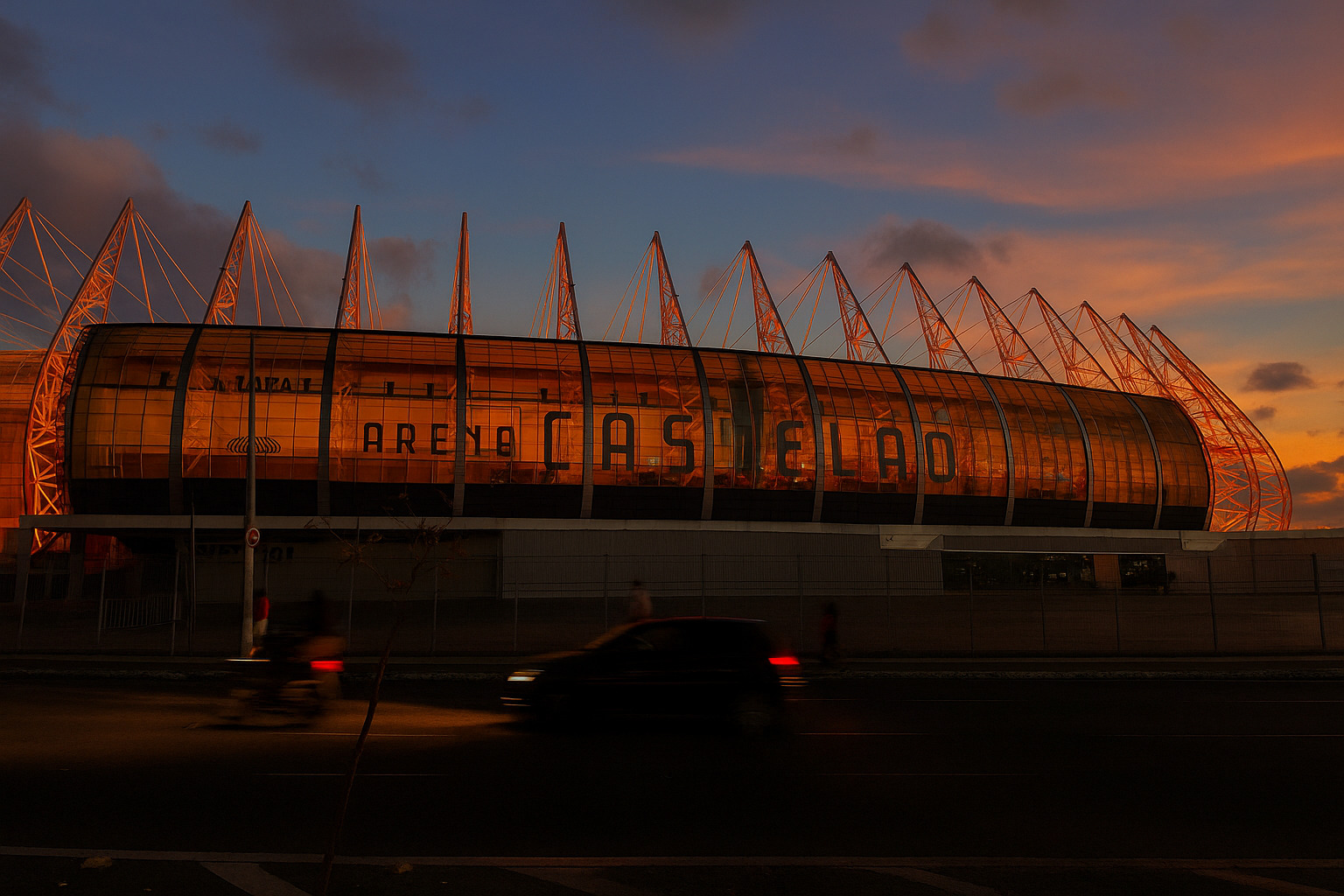 Arena Castelão iluminada ao entardecer com céu alaranjado.