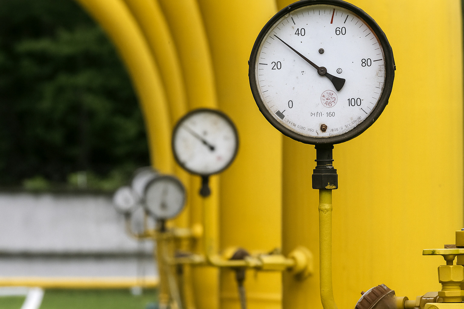 Medidores de pressão em tubulações industriais de gás sem presença de pessoas ao fundo.