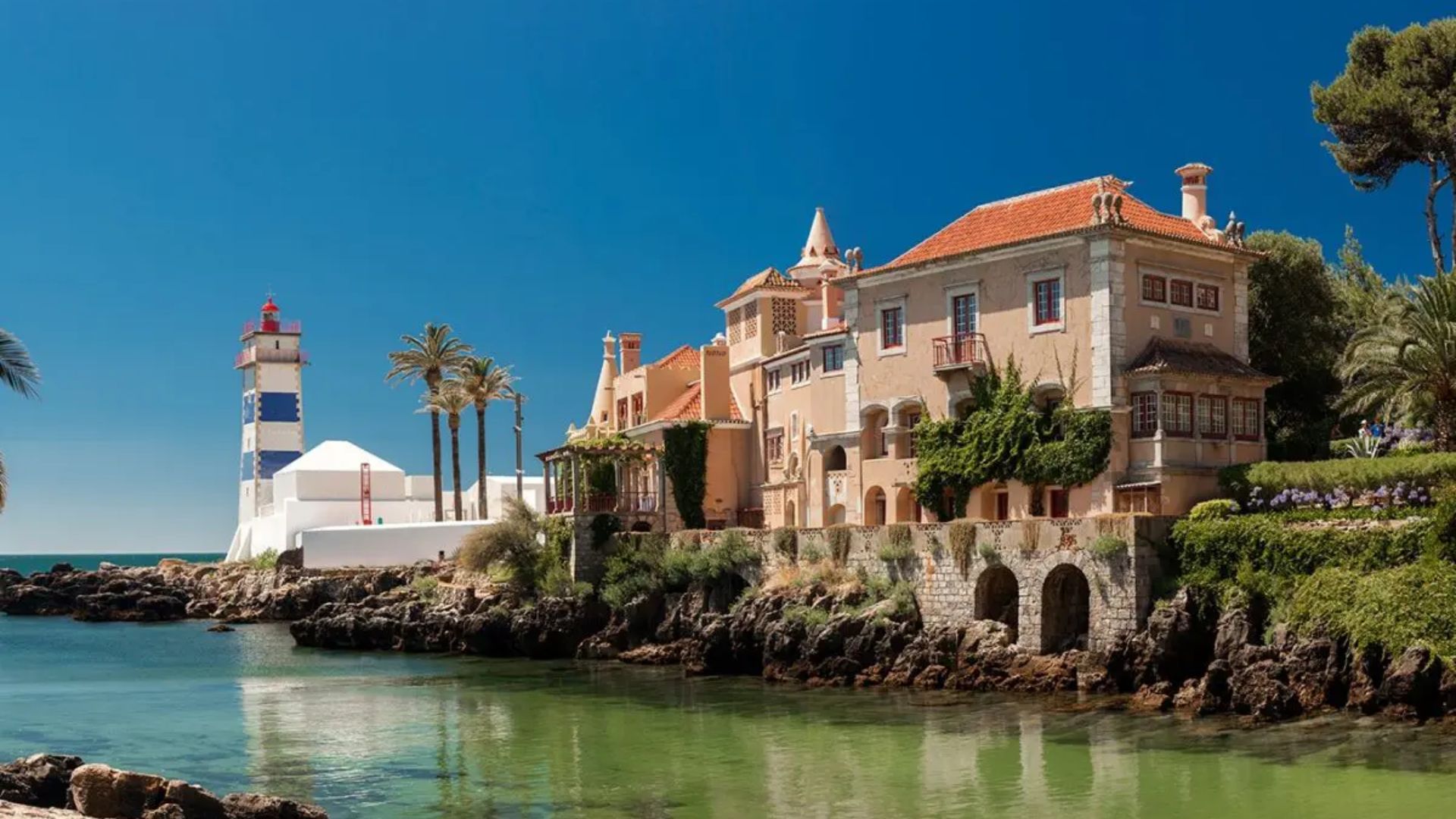Vista aérea da Baía de Cascais com imóveis de luxo à beira-mar.