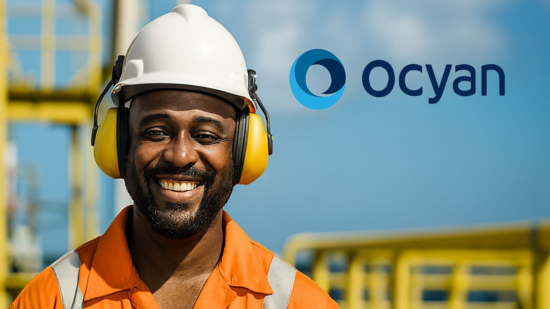 Trabalhador offshore negro sorrindo com uniforme laranja e logo da Ocyan ao fundo em ambiente industrial marítimo.