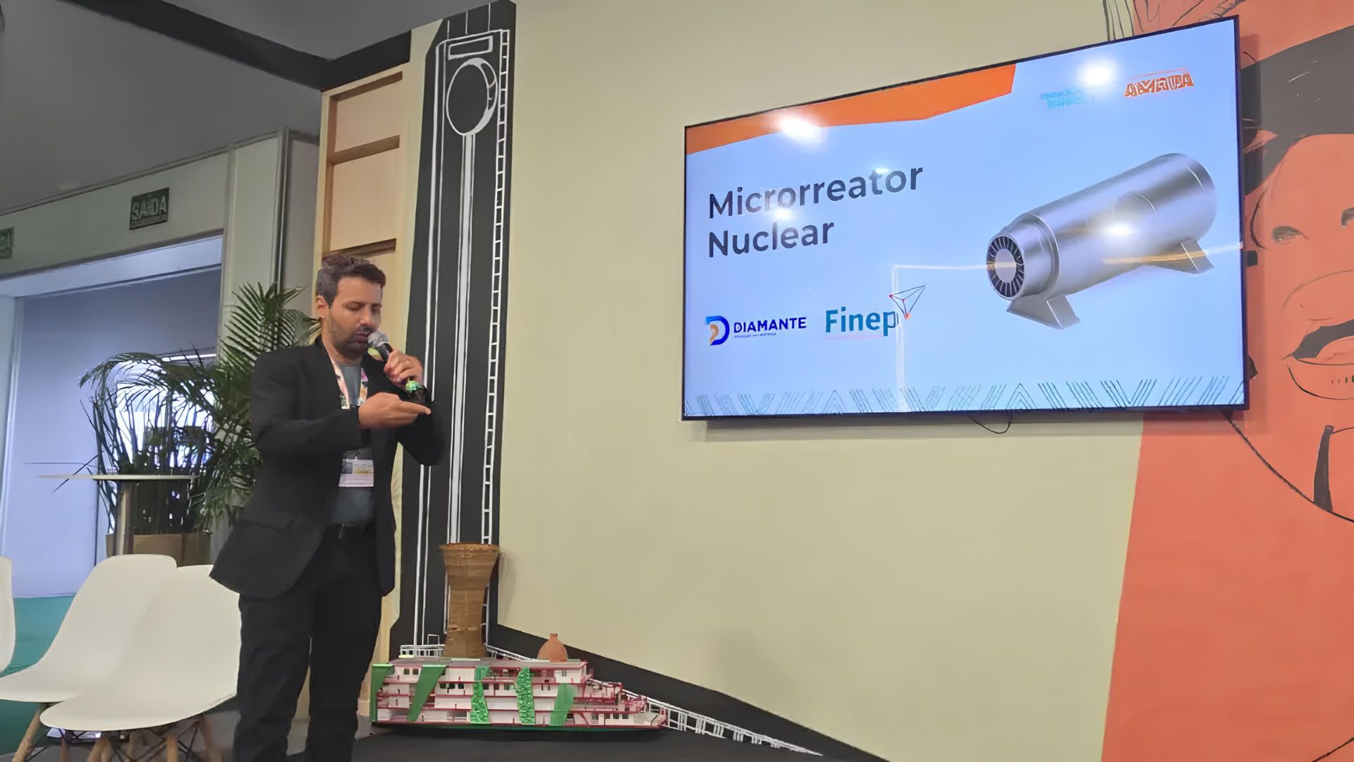 Apresentação de projeto de microrreator nuclear brasileiro pela Diamante Energia durante conferência, com slide técnico exibido em tela