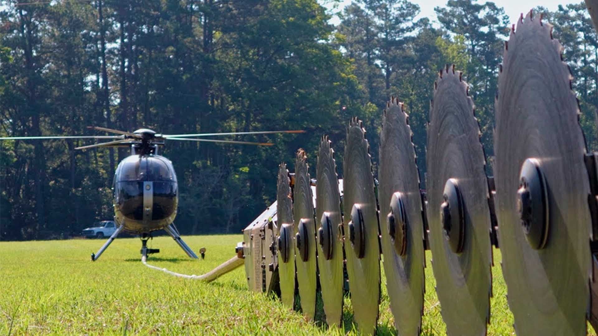 Helicópteros voando baixo com até 10 lâminas girando suspensas cortam galhos ao longo de corredores de energia para evitar contato da vegetação com a rede e reduzir risco de apagões