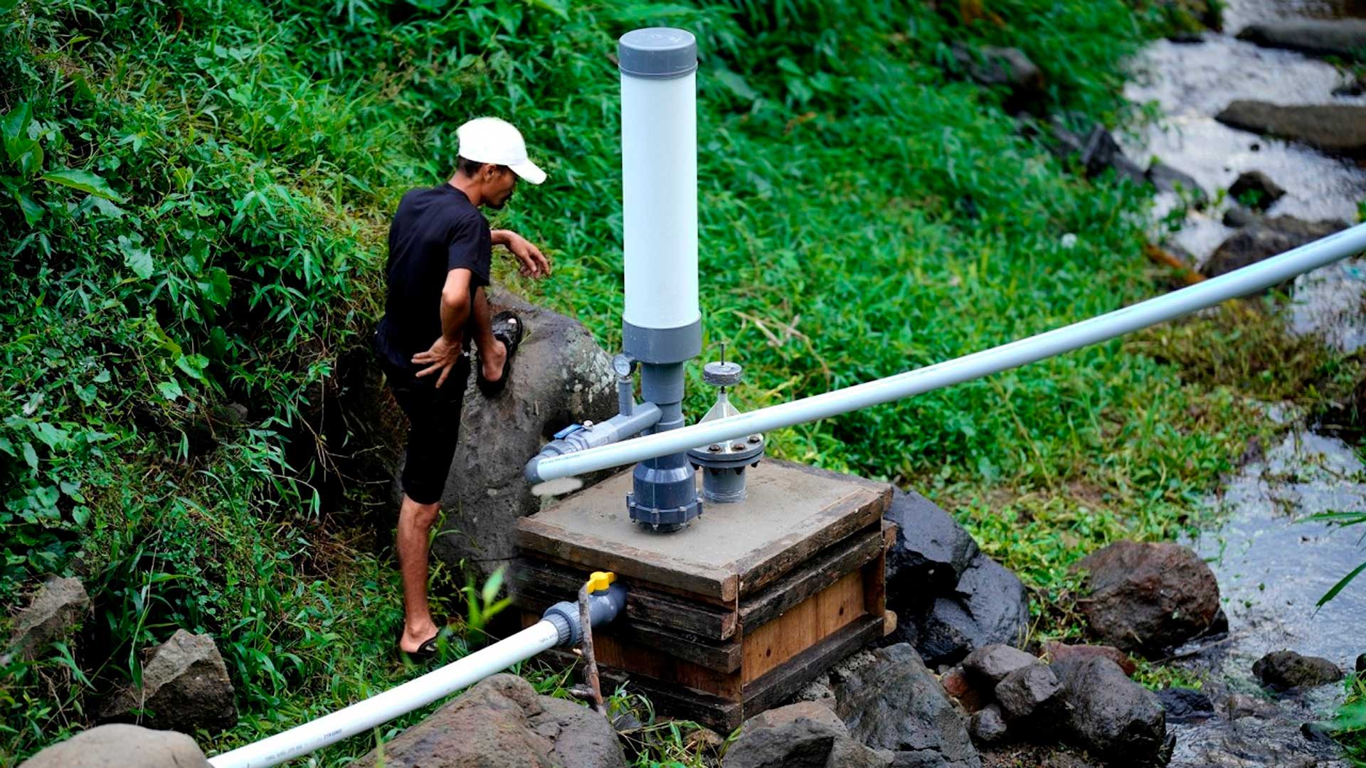 Homem constrói sozinho bomba que não usa eletricidade e consegue levar água morro acima aproveitando apenas a pressão do fluxo em um aríete hidráulico