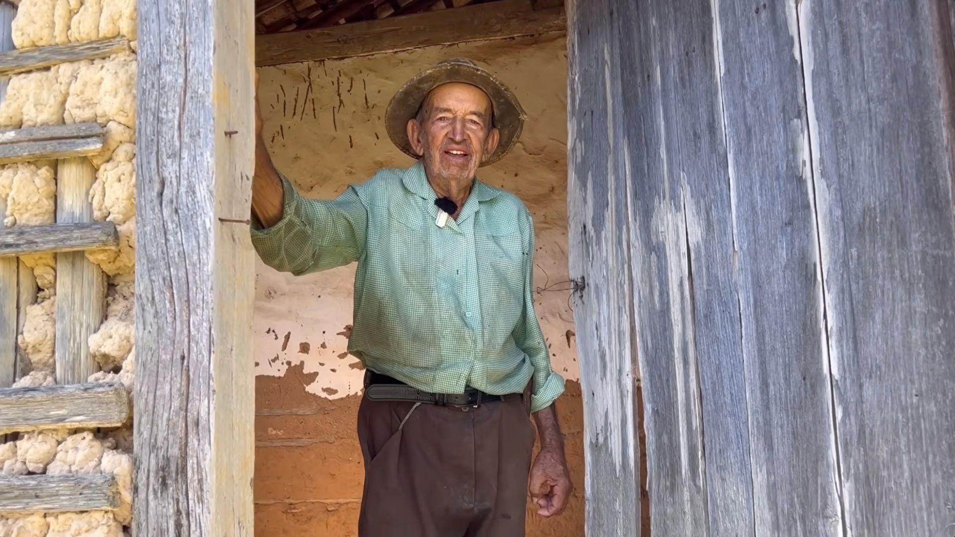 Agricultor de 86 anos em frente a casa de pau a pique centenária no interior de Minas Gerais