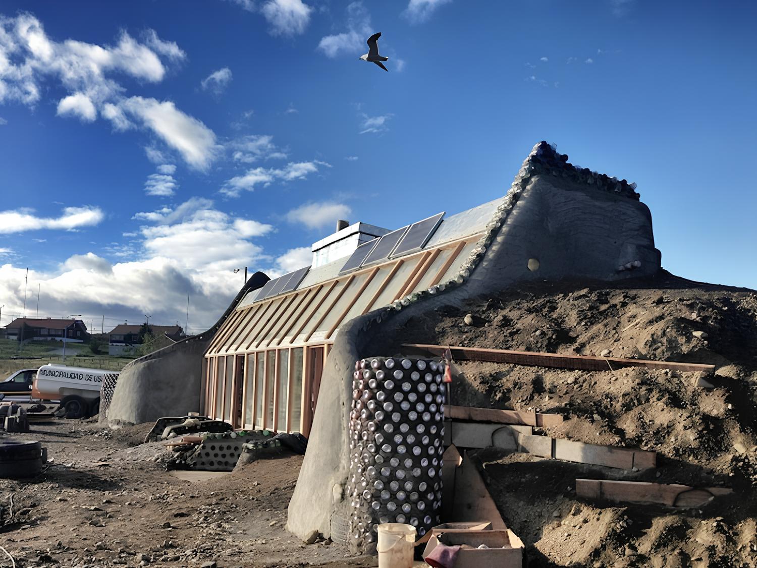 Casa construída com 333 pneus, 3.000 latas de alumínio e 5.000 garrafas de vidro no extremo sul da Argentina transforma resíduos em moradia térmica eficiente e prova que lixo urbano pode virar estrutura habitável permanente