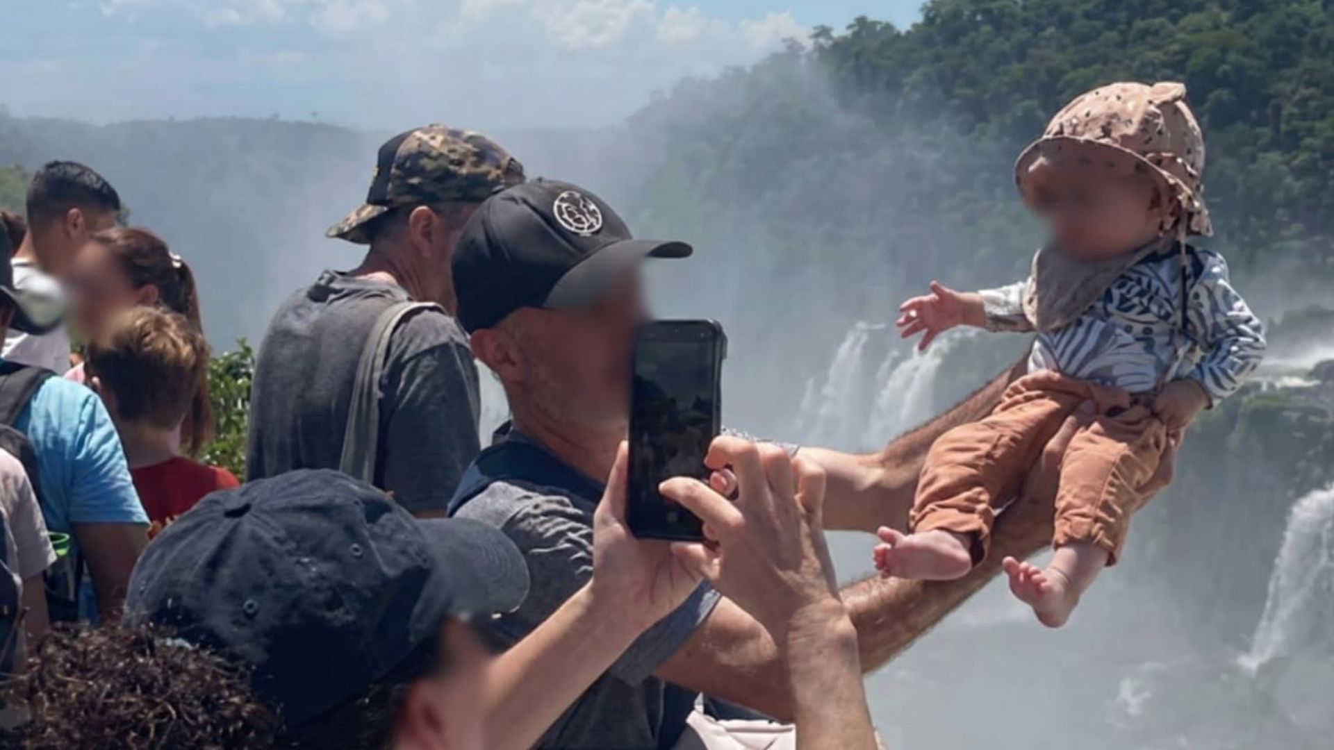 Bebê é erguido sobre a grade de proteção na Garganta do Diabo, nas Cataratas do Iguaçu.