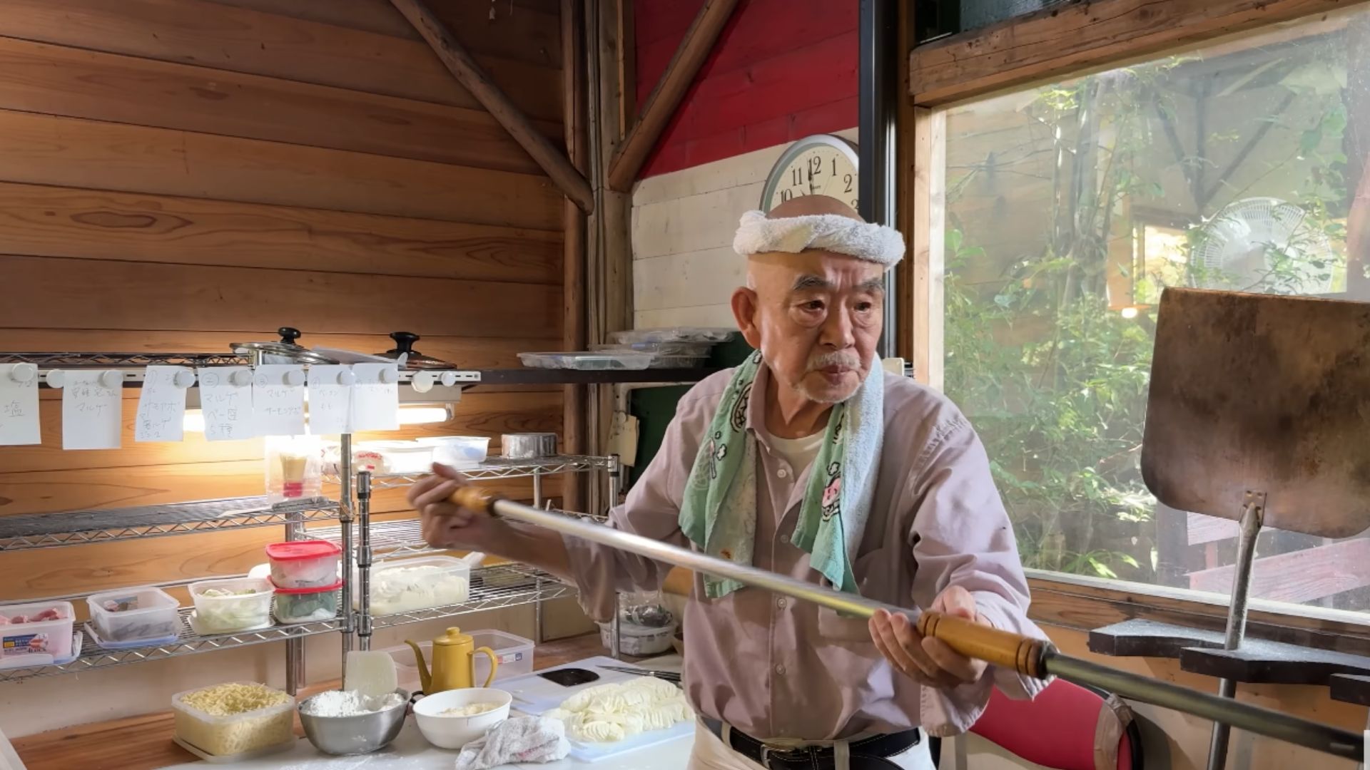 Pizzaiolo japonês idoso assando pizza em forno artesanal de pedra a mais de 500 graus