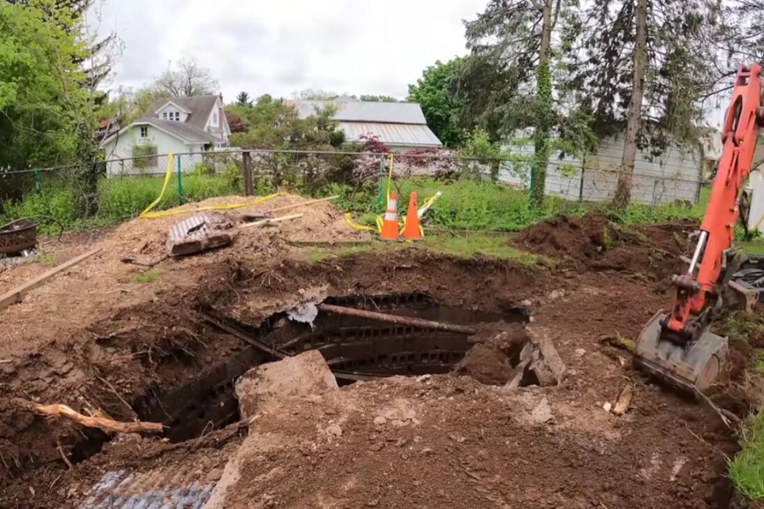 A strange hole reveals an underground concrete structure, raises suspicion of hidden bunker, and was ultimately identified as a septic tank.