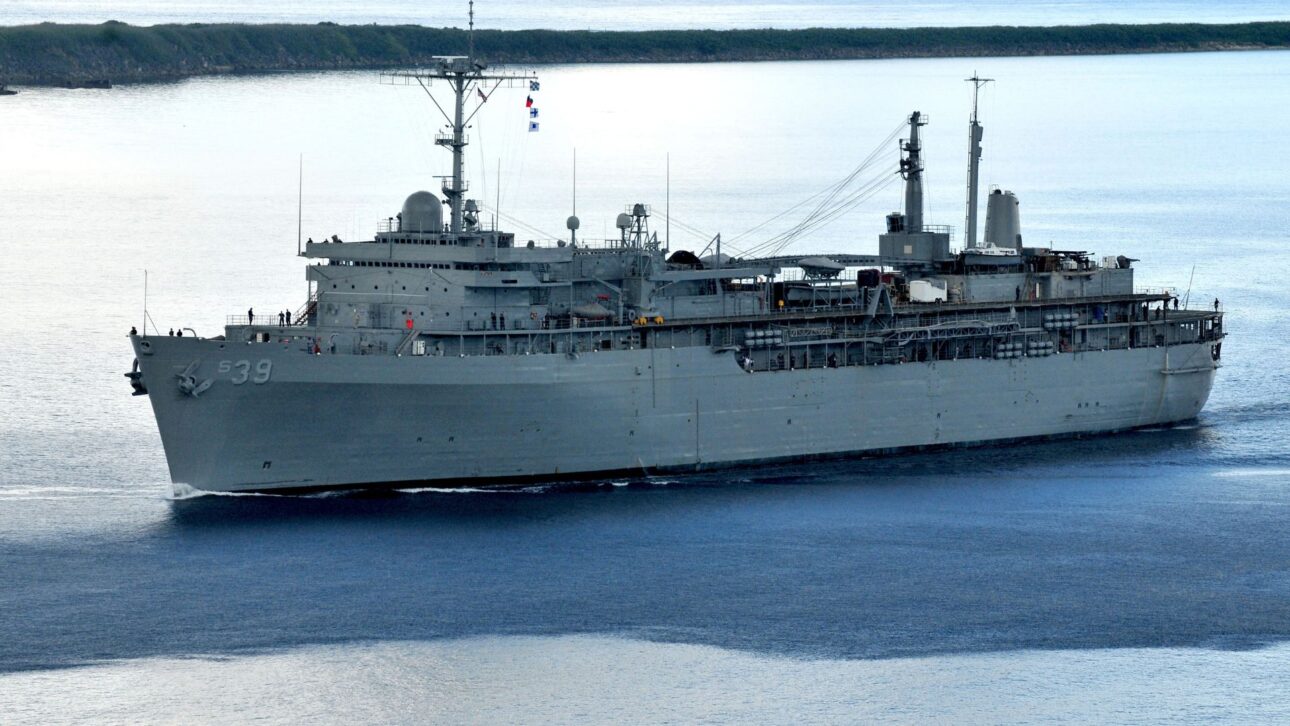 USS Emory S. Land: a workshop ship that keeps U.S. nuclear submarines operating away from shipyards and sustains naval presence in the Indo-Pacific.