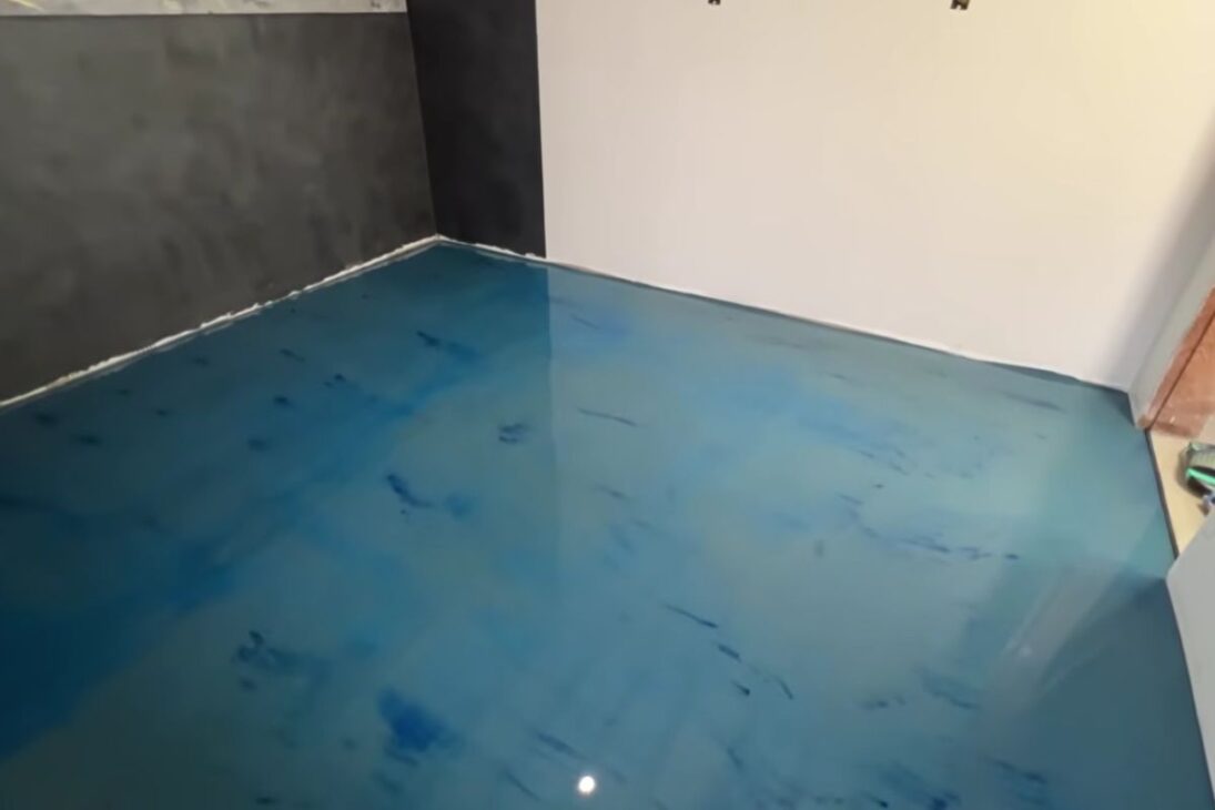 Pigmented liquid floor with self-leveling cement, resin, and blue pigment transforms home, studio, and garage with a few millimeters and modern finish.
