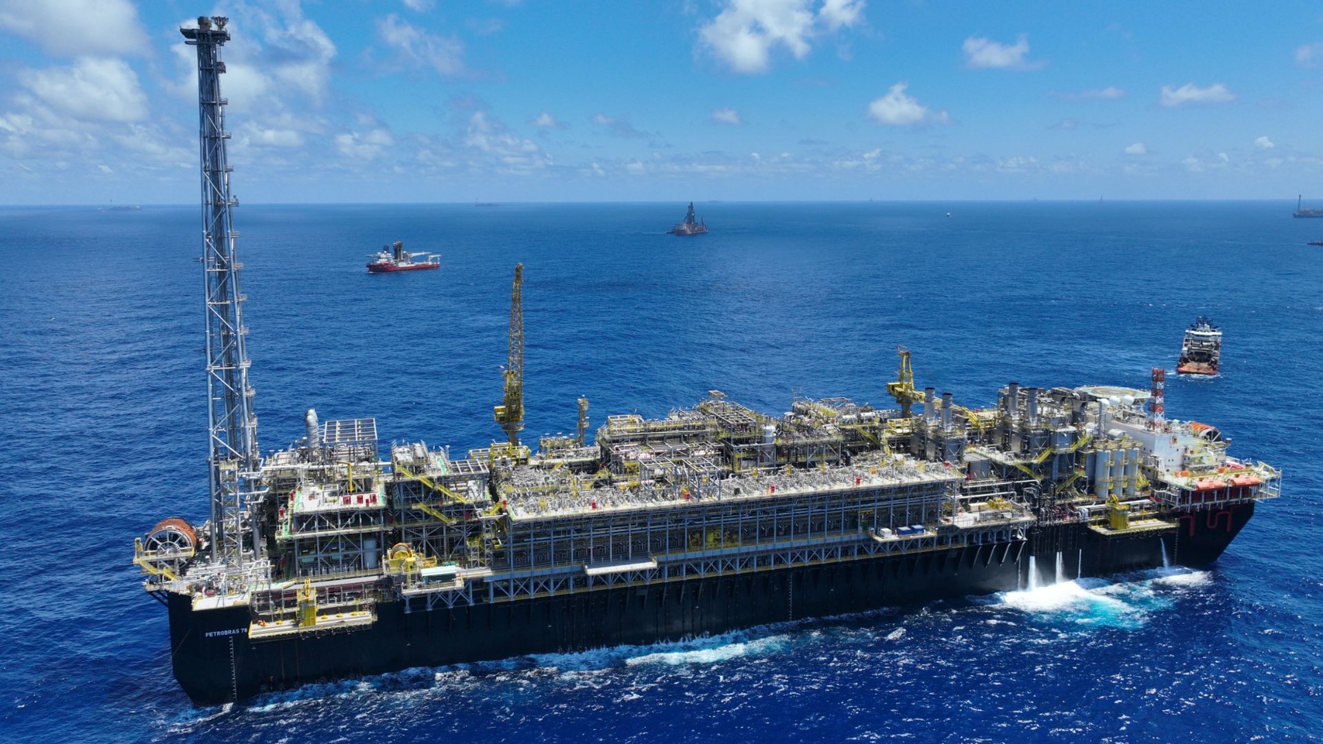 Plataforma offshore da Petrobras operando em alto-mar no Brasil, com estruturas industriais e navios de apoio ao redor, representando a produção de petróleo e gás no pré-sal.