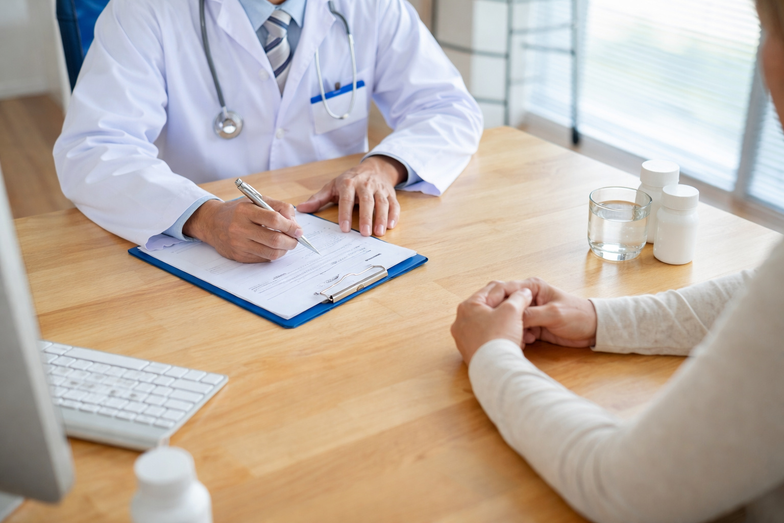 Médico anotando informações em prontuário durante consulta enquanto paciente relata problemas de saúde relacionados a afastamento médico do trabalho