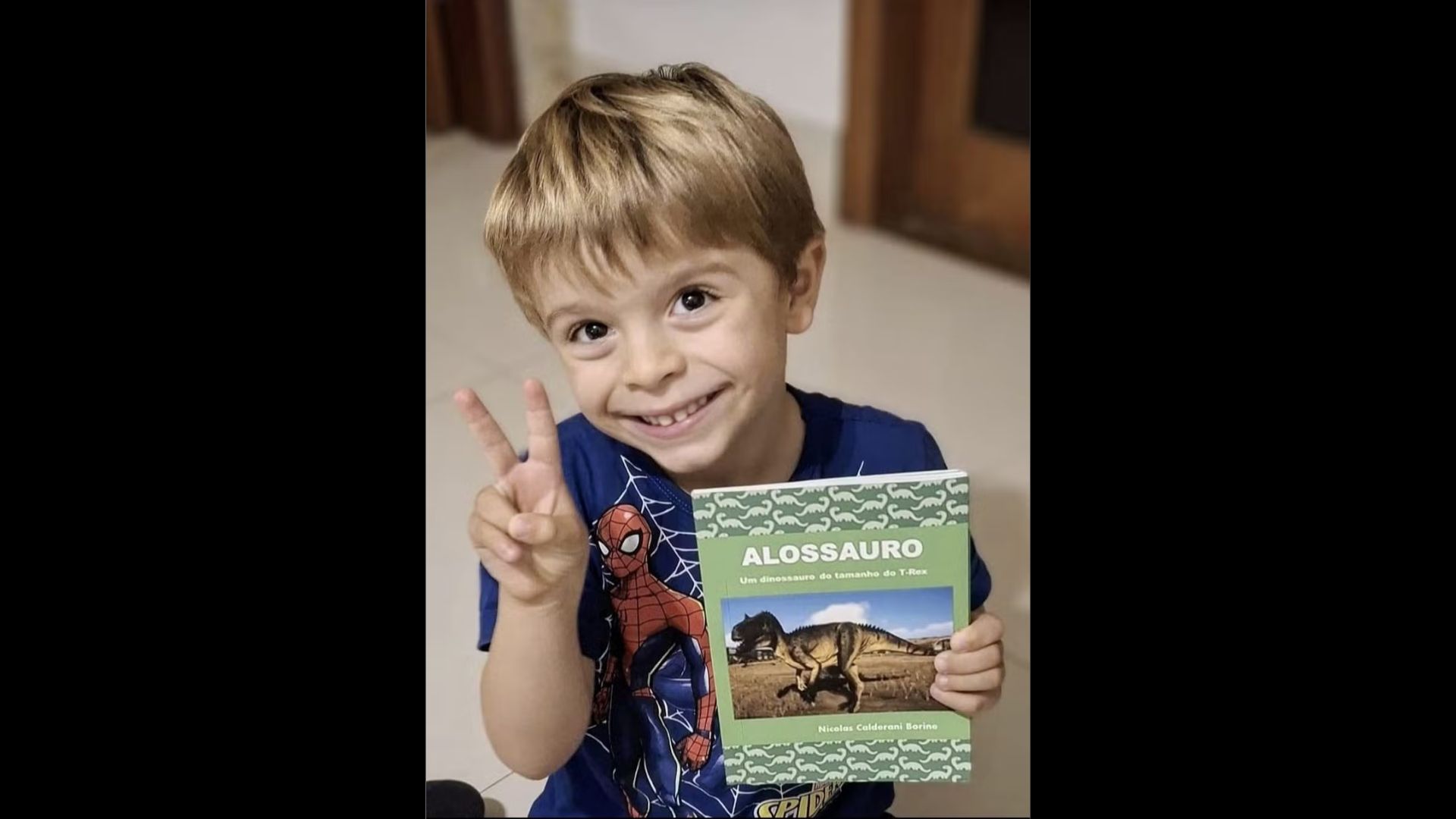 Menino de 4 anos desenhando livro sobre dinossauro em Atibaia
