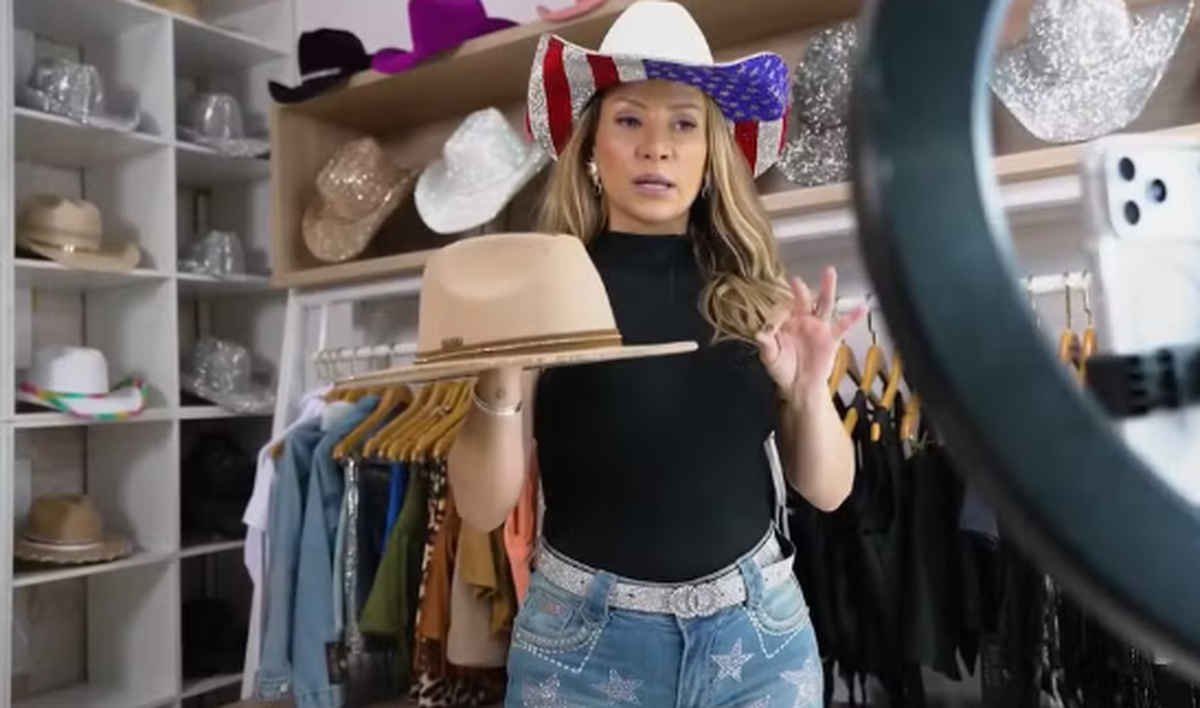 Empreendedora apresenta chapéu feminino em loja de acessórios, representando produção e venda de chapéus personalizados inspirados na história de Merope Papadellis.