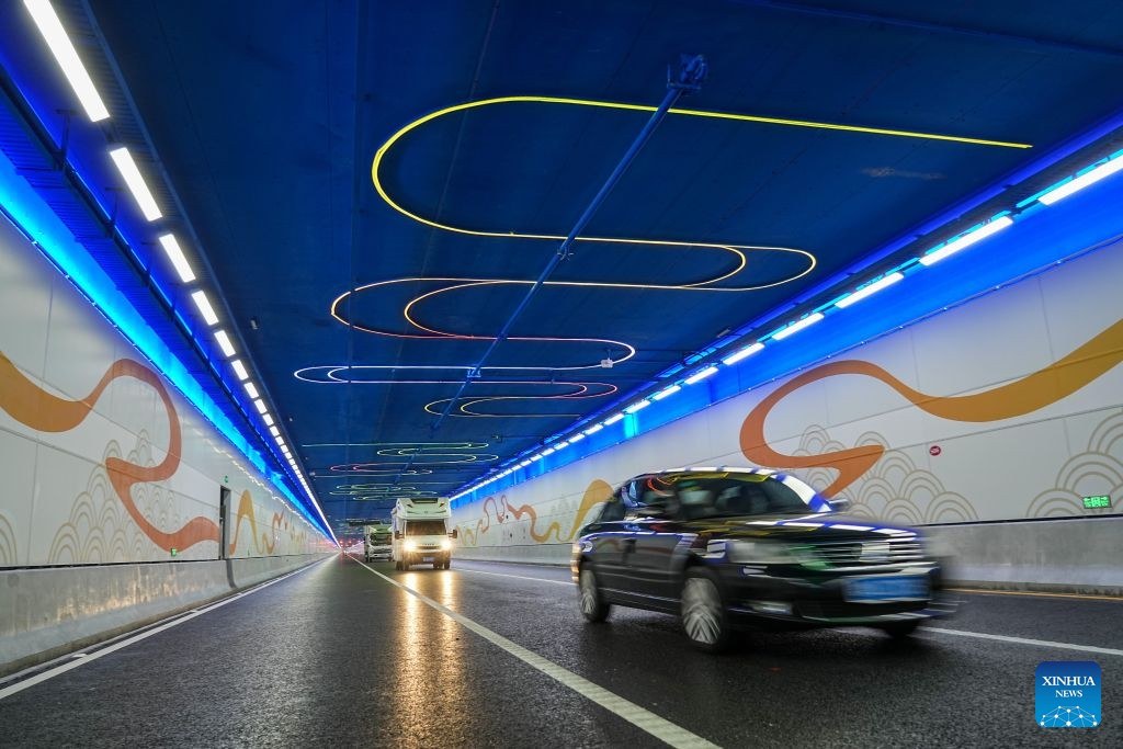 Vehicles traverse the illuminated tunnel beneath the Yellow River in Jinan